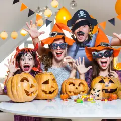 Famille costumée, joyeuse, prête à organiser soirée d'Halloween avec citrouilles sculptées et bonbons.
