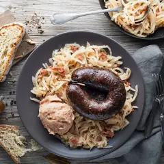 Kaszanka z grilla podana z kapustą kiszoną i chlebem. Pyszne danie, które rozgrzewa.