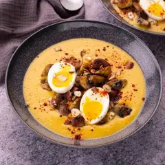 Velouté de patate douce garni de champignons, de noisettes et d'un œuf mollet.