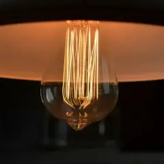 Żarówka Edisona z widocznym żarnikiem, idealna jako jaka żarówka do lampki nocnej, tworzy ciepły, przytulny blask.