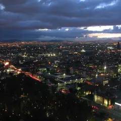 Nocny widok na rozświetlone miasto, które może być stolicą Meksyku, gdzie mieszka wiele ludzi.