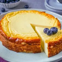 Ein saftiger Quarkkuchen ohne Boden, goldbraun gebacken und mit frischen Blaubeeren garniert. Ein Genuss für jeden Kaffeetisch!