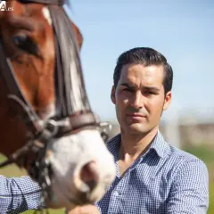 Alberto Sandoval, picador, posa junto a un caballo castaño con brida.