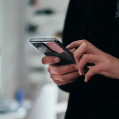 Dłonie trzymające nowoczesny smartfon, widok z bliska.