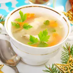 Aromatyczna zupa rybna przepis prosty, podana w eleganckiej miseczce, ozdobiona gałązkami choinki i złotymi gwiazdkami.