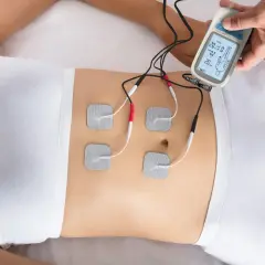 Elektrostymulacja mięśni brzucha za pomocą urządzenia z elektrodami.