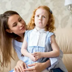 Smutna dziewczynka z rudymi włosami, pocieszana przez mamę. Może to przygotowania do złożenia wniosku do sądu o zmianę szkoły?