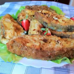 Chrupiący halibut smażony, podany na liściach sałaty z kawałkami truskawek. Pyszne danie!