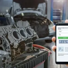 Mecánico revisa un motor de Ford con un teléfono que muestra el DTC P1693, indicando una avería en el circuito de control del turbo.