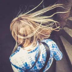 Rubia con pelo al viento, buscando cómo aclarar el pelo naturalmente.