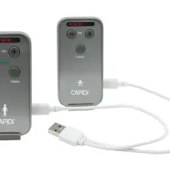 Två grå enheter med texten CAPIDI och knappar för volym, mikrofon, vibration och ström. En vit USB-kabel kopplar ihop dem. En trygghet med capidi babyalarm.