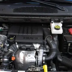 Silnik 1.6 HDI w Berlingo. Widoczny blok silnika, turbosprężarka, przewody i akumulator.