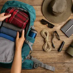 Preparando el equipamiento para el Camino de Santiago: mochila, ropa, botas, sombrero, gafas de sol, cuerda, linterna, libreta y esterilla.