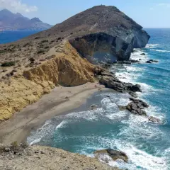 Paisaje de la cala amarilla en Almería, con acantilados dorados, arena y mar azul turquesa.