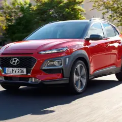 Czerwony Hyundai Kona w ruchu ulicznym. Sprawdź jego kompaktowe hyundai kona wymiary, idealne do miasta.