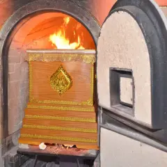 Płomienie otaczają drewnianą trumnę w piecu kremacyjnym, pokazując, co się dzieje z ciałem podczas kremacji.