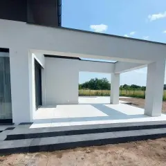 Nowe schody i taras z białej kostki betonowej przy nowoczesnym domu.