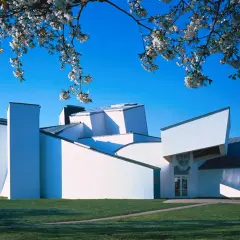 Das Vitra Museum Weil am Rhein, ein architektonisches Meisterwerk, erstrahlt im Frühlingslicht unter blühenden Kirschbäumen.
