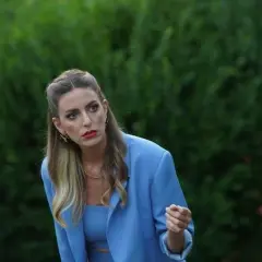 Eda z "Zapukaj do moich drzwi" w błękitnym żakiecie, z burzą blond włosów i wyrazistym makijażem, spogląda z uwagą w bok.