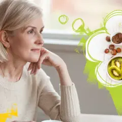 Äldre kvinna funderar över hälsosam mat med lax, avokado, nötter och kiwi. Fett som en del av en balanserad kost.