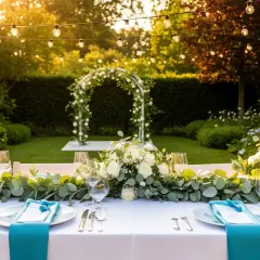 Festlich gedeckter Tisch im Garten mit Blumen und Lichterkette. Perfekte gartenhochzeit deko für eine romantische Feier unter freiem Himmel.