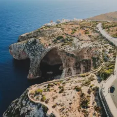 Malta widoki: klify, jaskinie morskie i kręta droga nad turkusowym morzem.