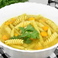 Zupa z makaronem i żółtą fasolką szparagową, ozdobiona natką pietruszki. Pyszne dania z fasolki szparagowej żółtej.