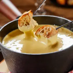 Des morceaux de pain trempés dans une fondue au fromage crémeuse. Un délice de pain fondue à partager.