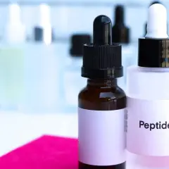 Dwie buteleczki z pipetkami, jedna z napisem "Peptide". Pamiętaj, z czym nie łączyć peptydów miedziowych, by uniknąć podrażnień.
