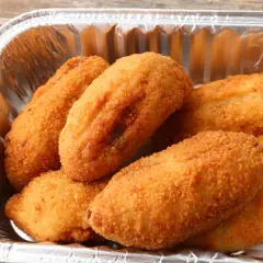 Croquetas de pollo doradas y crujientes en un recipiente de aluminio, listas para disfrutar.