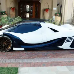 Devel Sixteen, un coche futurista blanco y azul oscuro, listo para alcanzar su velocidad máxima.