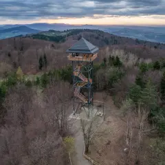 Wieża widokowa Kamionna góruje nad lasem, oferując zapierający dech w piersiach widok na pasmo górskie o zachodzie słońca.