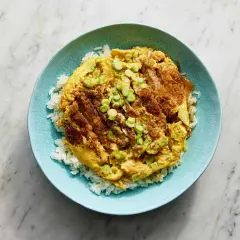 A delicious katsu donburi recipe, featuring crispy fried pork cutlet over fluffy white rice, topped with a savory egg and green onions.