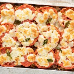 Pomodori al forno con mozzarella filante e basilico. Un'idea gustosa per cosa mangiare stasera, semplice e veloce da preparare.