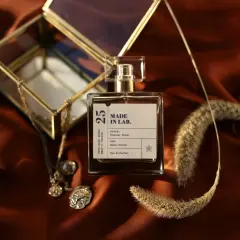 Elegancka butelka perfum "Made in Lab" na satynowym tle. Zastanawiasz się, co dłużej pachnie: woda toaletowa czy perfumowana?