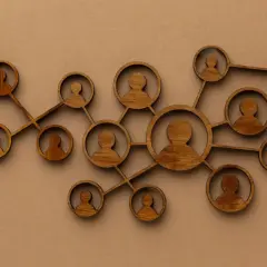 Drewniane figurki ludzi połączone ze sobą, symbolizujące podejście systemowe w psychologii i relacje międzyludzkie.