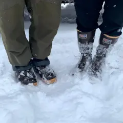 Two pairs of winter boots in snow. The Xtratuf boots fit snugly, allowing for thick socks.