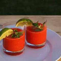 Två glas med en uppfriskande strawberry daiquiri, garnerade med lime och mynta. Perfekt för en solig sommardag.