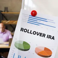 Paper titled "ROLLOVER IRA" with charts and graphs, showing financial data. Charitable contributions from IRAs are no longer allowed.