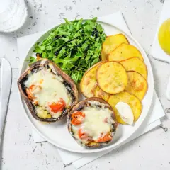 Portobello que es: dos champiñones rellenos de queso y tomate, acompañados de patatas fritas y ensalada.