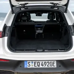 Maletero abierto de un Mercedes EQA blanco, listo para cargar equipaje en un viaje a la costa.