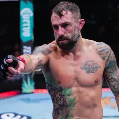 Michael Chiesa, med tatuerat bröst och armar, pekar framåt i oktagonen.
