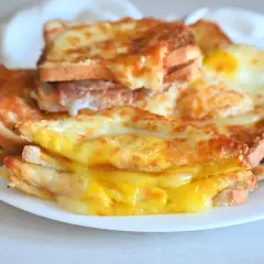 Toast filanti e dorati, preparati nella friggitrice ad aria, con formaggio fuso e un uovo.