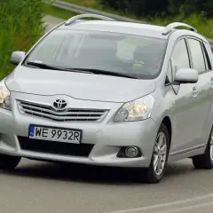 Srebrny Toyota Verso S jedzie po drodze, za kierownicą siedzi osoba.