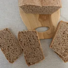 Kromki ciemnego chleba na desce, aż chce się jeść, ale potem może pojawić się zgaga po chlebie.