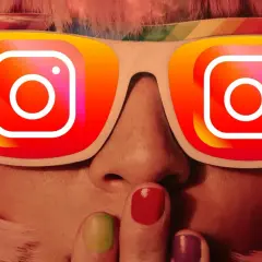 Osoba z kolorowymi włosami i paznokciami, w okularach z logo Instagram. Chcesz wiedzieć, jak zrobić podsumowanie roku na Instagramie?