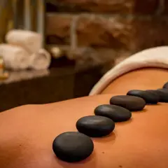 Varm stenmassage för att lindra ont i ryggen gravid. Avslappnande behandling med varma stenar på ryggen.