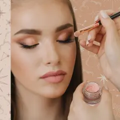 Guida per imparare come fare un make up perfetto: applicazione di ombretto scintillante con pennello su un occhio di una modella.