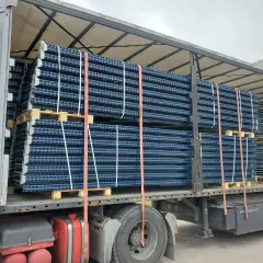 Przesyłka paletowa z niebieskimi regałami magazynowymi, zabezpieczona pasami, gotowa do transportu.