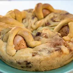Casatiello napoletano ricetta della nonna: un rustico profumato con uova intere incastonate nell'impasto intrecciato, pronto per essere gustato.